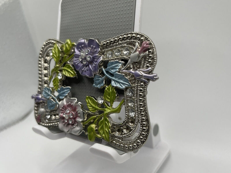 Silver toned clear Rhinestone floral pattern belt buckle.