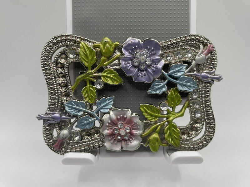 Silver toned clear Rhinestone floral pattern belt buckle.